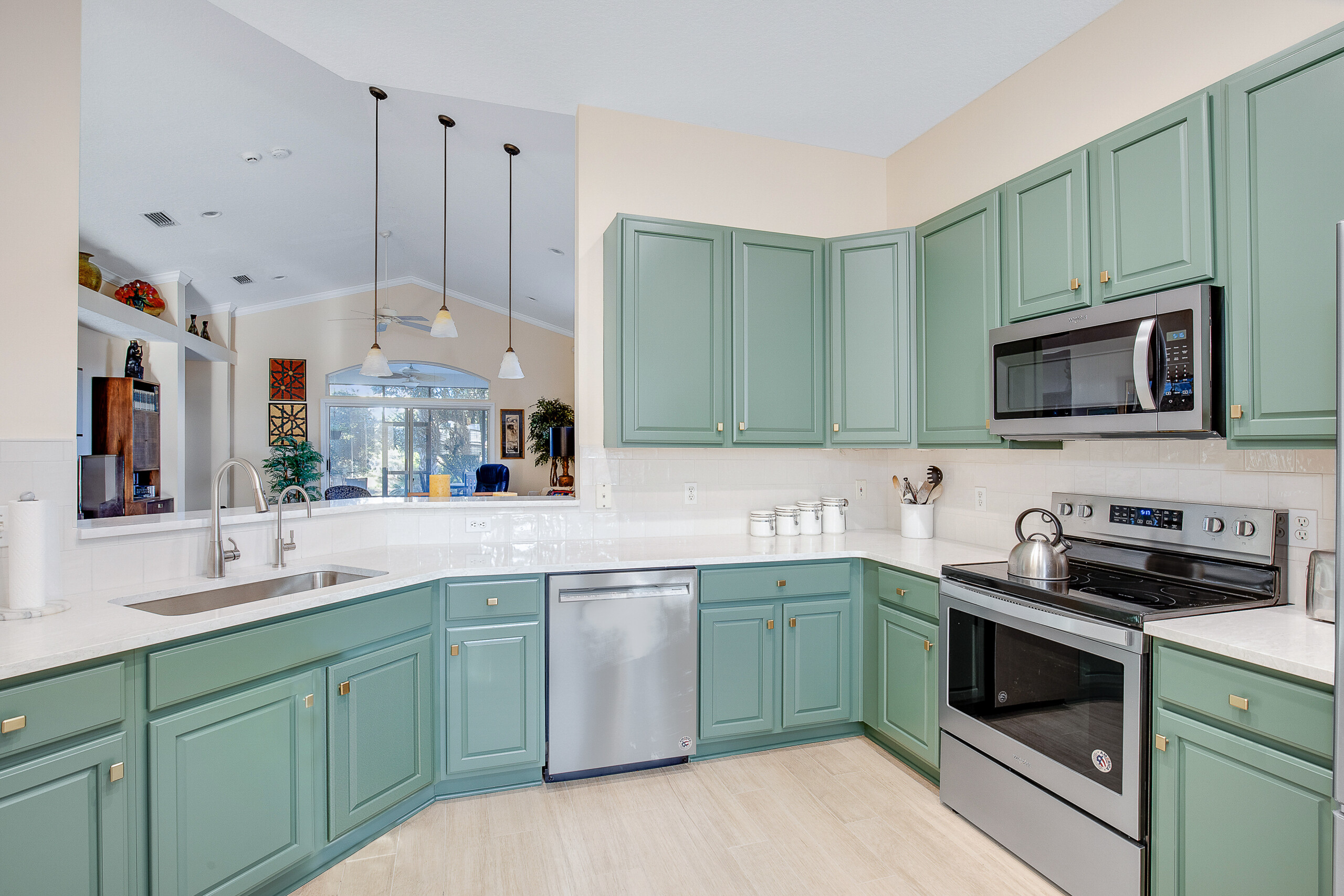 Professional painter masking and prepping cabinets before painting in a busy Harrisburg, NC family kitchen