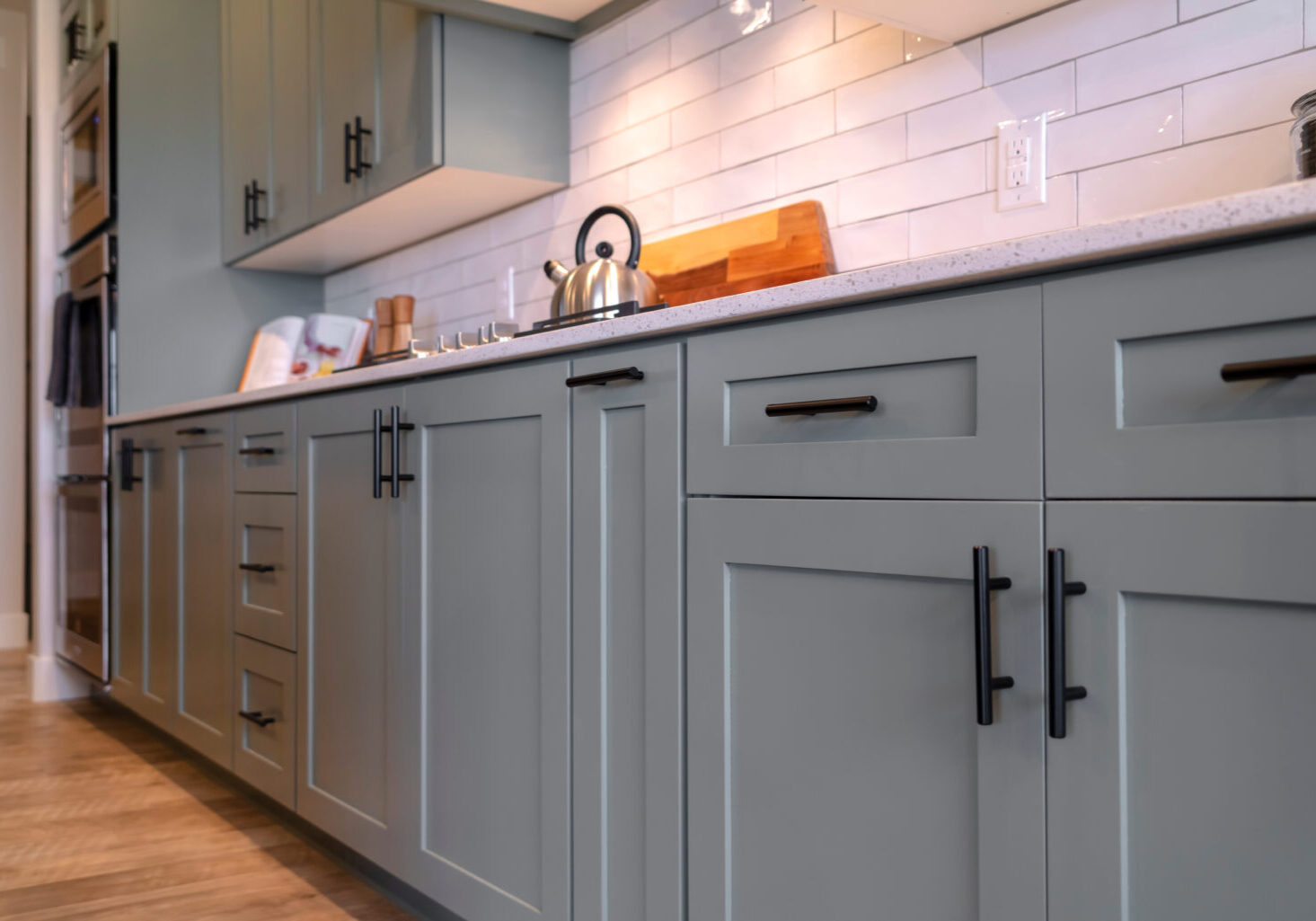 Skilled painter using specialized tools to prepare and repaint cabinets in a well-lit McAdenville, NC kitchen