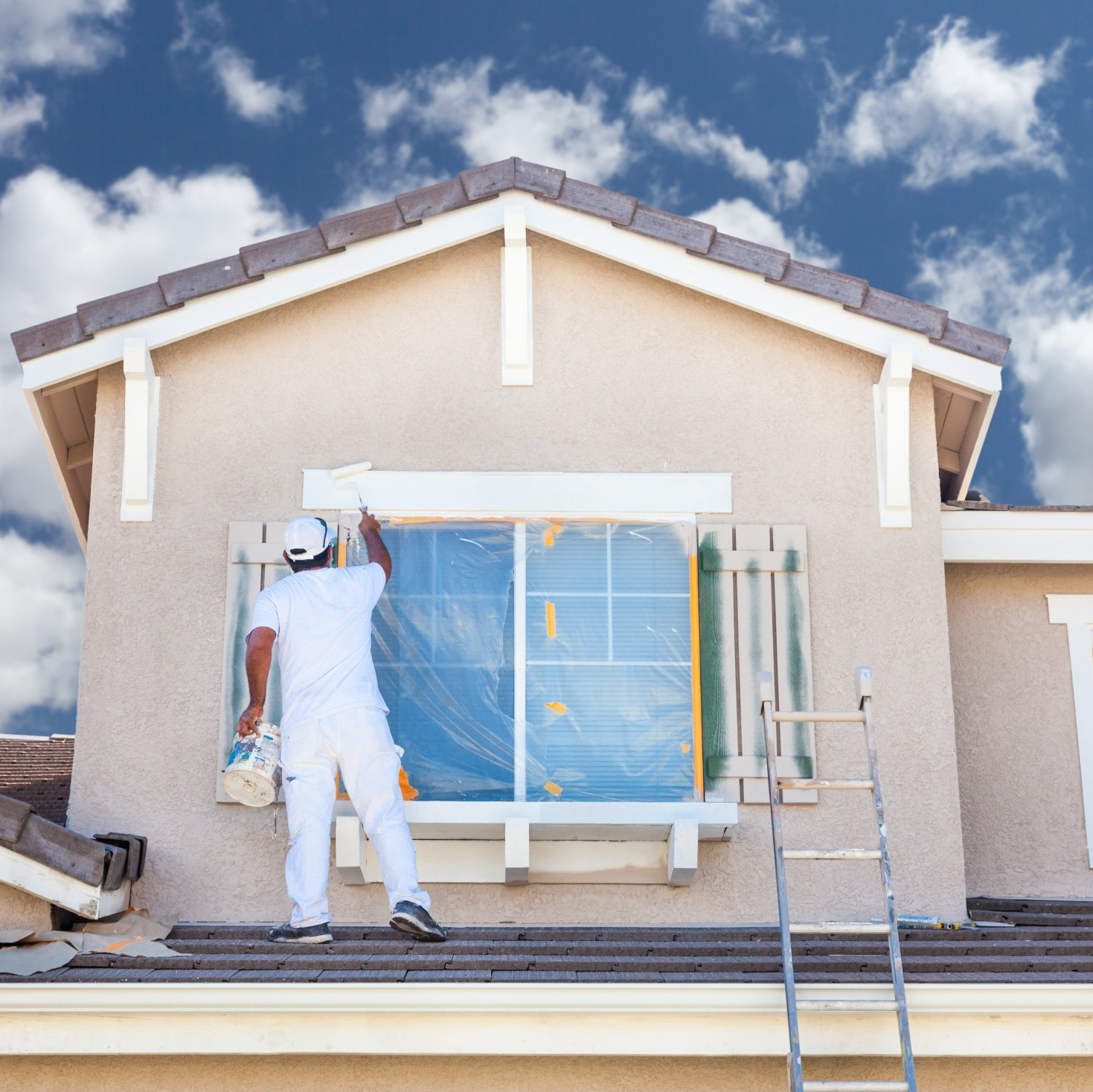 Experienced painter inspecting trim, caulk lines, and siding before exterior paint application