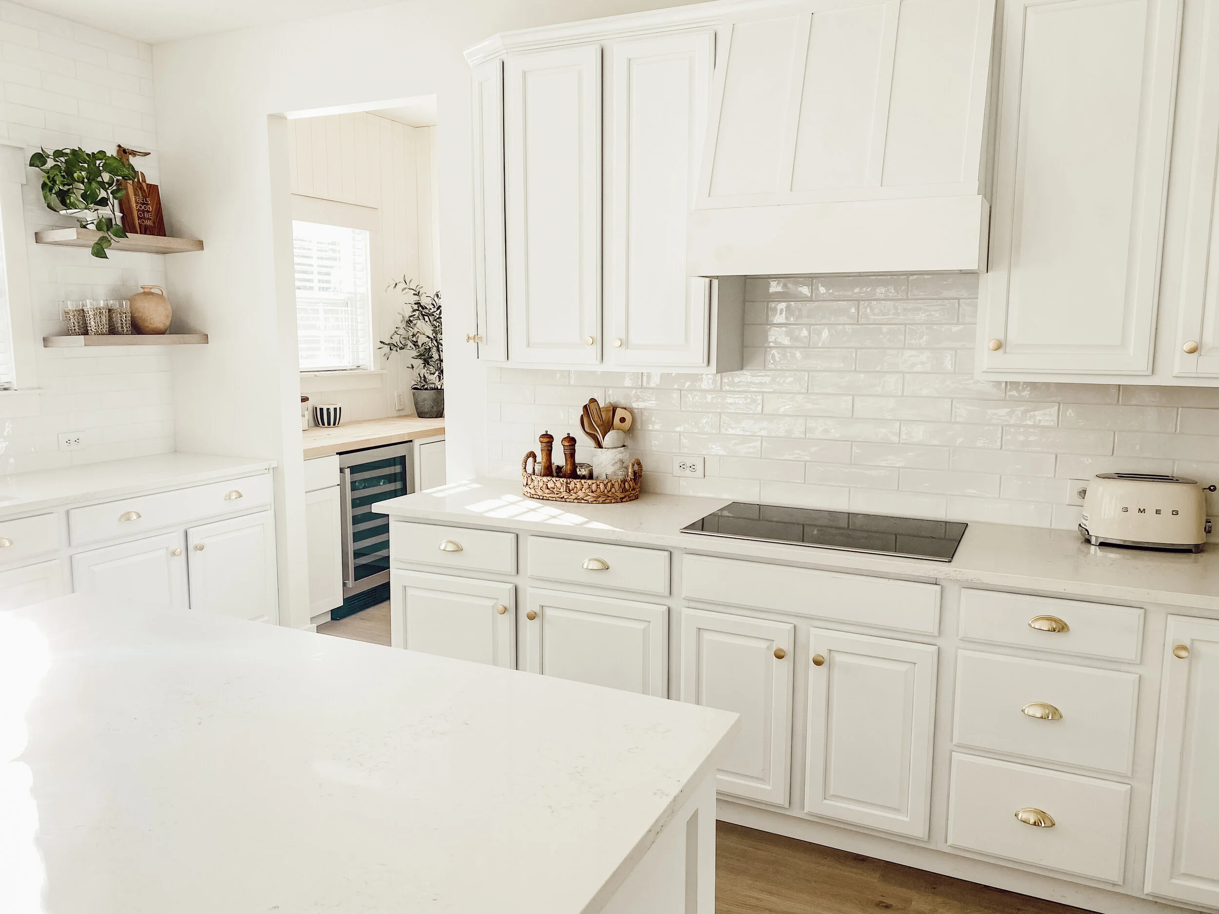 Painter applying fresh white paint to classic kitchen cabinets in a Cramerton, NC home for a budget-friendly makeover