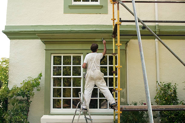 Painter applying fresh exterior paint to Cornelius, NC home with careful surface preparation
