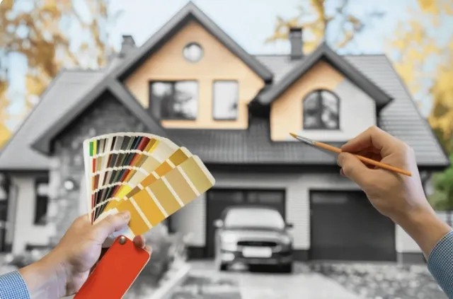 Experienced painter using professional tools to apply even coat to large Cornelius, NC home exterior