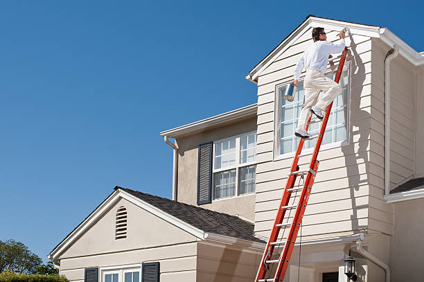 Experienced painter applying protective coating to Marvin, NC home exterior using professional equipment and safety gear