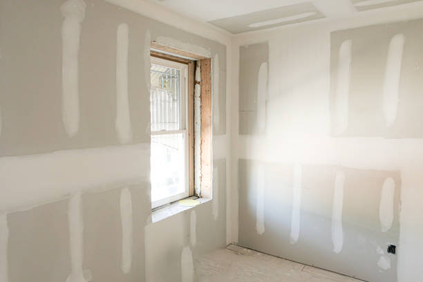 Drywall Repairs in Cornelius, NC underway as a technician sands a patched interior wall