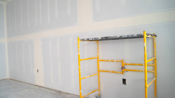 Specialist completing drywall repairs on a ceiling corner inside a Huntersville, NC home