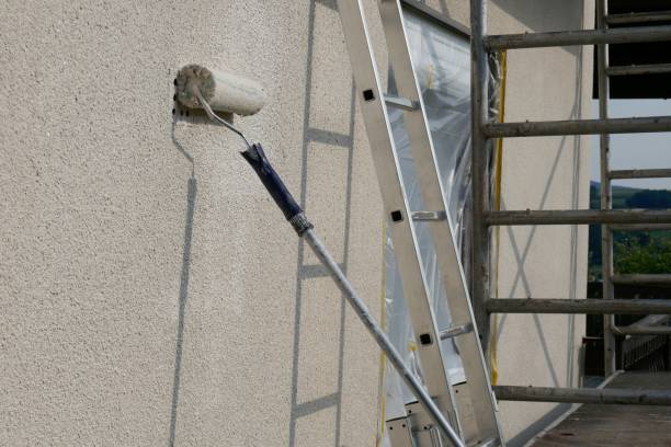 Crew performing exterior painting on trim and siding in Mount Holly, NC during a careful daytime setup