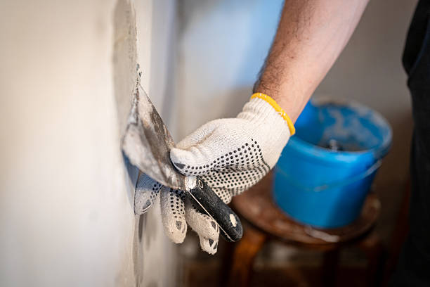 Drywall Repairs in Concord, NC in progress as a technician sands a patched interior wall